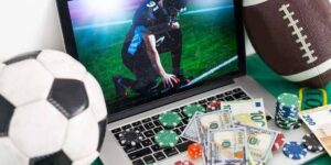 Laptop showing an American football player, surrounded by poker chips, cash, a soccer ball, and a football, symbolizing sports betting.