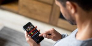 Man browsing a sports betting app on his phone at home.