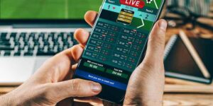 Person using mobile phone app displaying tools for betting cricket matches in real-time