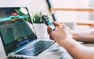 Man using AI betting bots on mobile and laptop during live sports betting