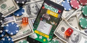 Mobile sports betting app surrounded by casino chips, dice, and US dollar bills 