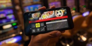 Hand holding smartphone showing live football betting odds, symbolising bookmakers vs betting bots.