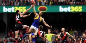 Players from two Australian Football League teams contest a high ball during a match, with a visible bet365 banner in the background, symbolising the excitement of those who bet on AFL games.