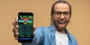 Person holding a phone showing a live betting screen, highlighting matched betting opportunities.