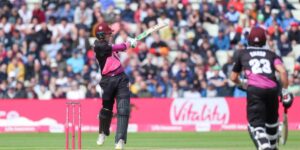 Professional cricketer playing an attacking shot during a competitive match in front of a full crowd