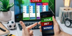 Live sports betting dashboard on laptop with winning bet notification on smartphone