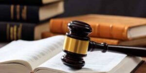 Judge’s gavel resting on an open law book with legal books in the background